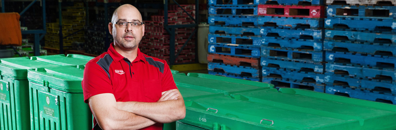 Jade Stolen, Edmonton Warehouse Supervisor, with new compost bins at the Edmonton distribution centre.